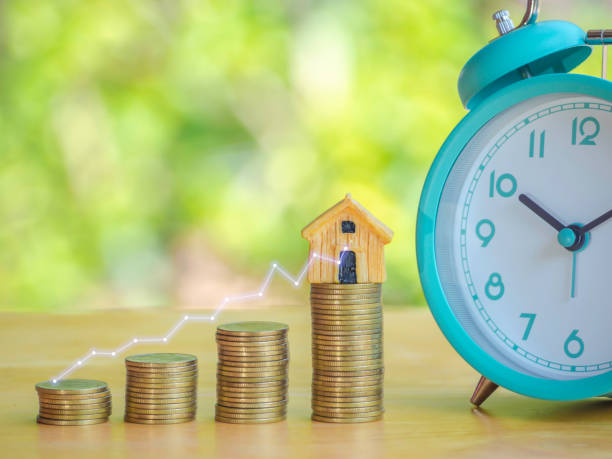 istock Hand are stacking coins with alarm clock to save the financial stability for the future. Concept for loan, property ladder, financial, mortgage, real estate investment, taxes and bonus. 1397744024