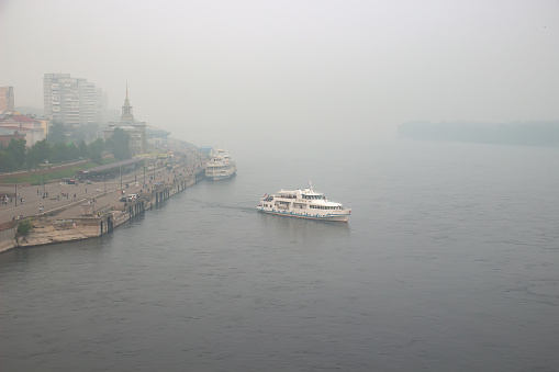 Krasnoyarsk, Russia - August 8, 2021: Landscape with thick smog over the Yenisei River in the center of Krasnoyarsk. Smoke from forest fires and industrial enterprises pollutes the environment
