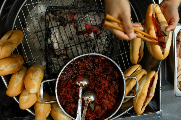 Directly above view of hands stuffing pork into banhmi