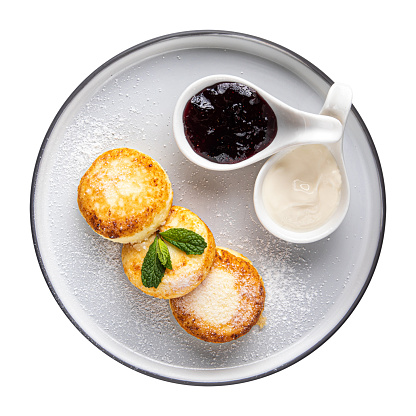Isolated plate of cottage cheese pancakes syrniki with jam