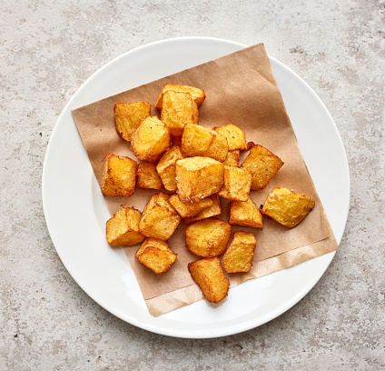 portion of fried potatoes on white restaurant plate, top view
