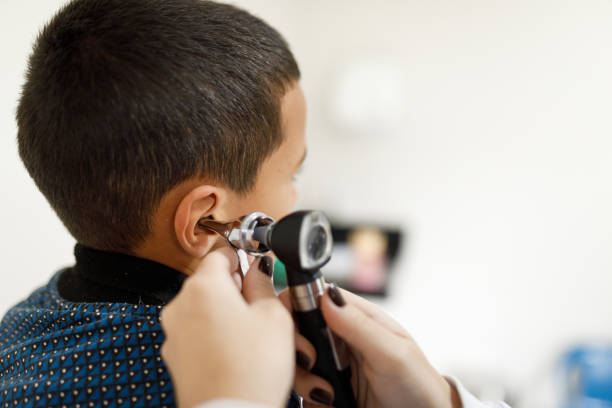 medico che controlla le orecchie del bambino con un otoscopio - esame otorino foto e immagini stock
