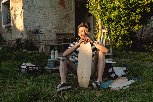 Portrait of proud male Caucasian entrepreneur and craftperson, working at his outdoor workshop