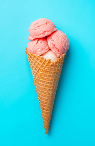 Ice cream on a blue background. Three balls of berry ice cream in a waffle cup on a blue background.