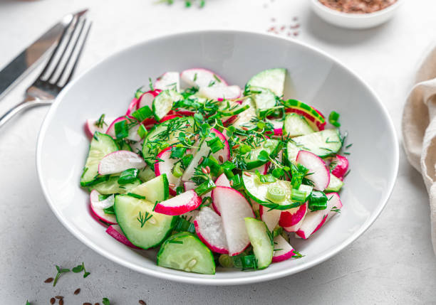 istock Fresh salad with radish and cucumber on a gray background. Side view, close-up. 1397755636