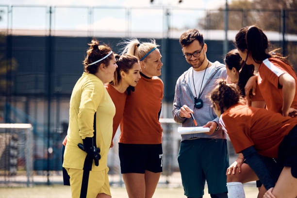 istock Female players and their coach going through game strategy before soccer match on playing field. 1397755953