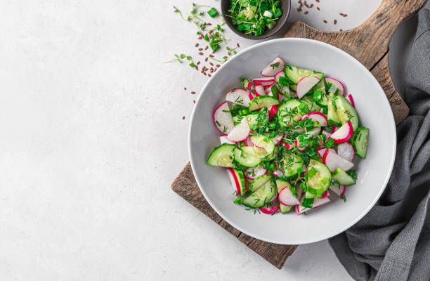 istock Summer vegetable salad with radish, cucumber and herbs on a gray background. 1397756864