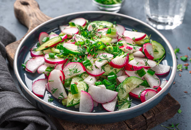 istock Salad with radish, cucumber and fresh herbs on a dark blue background. 1397757245