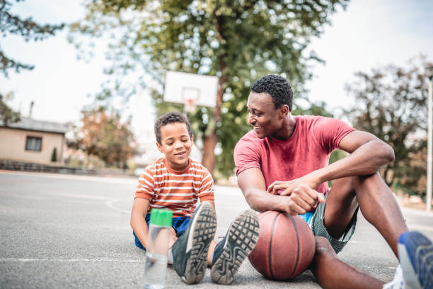 Father and son playing basketball stock photo