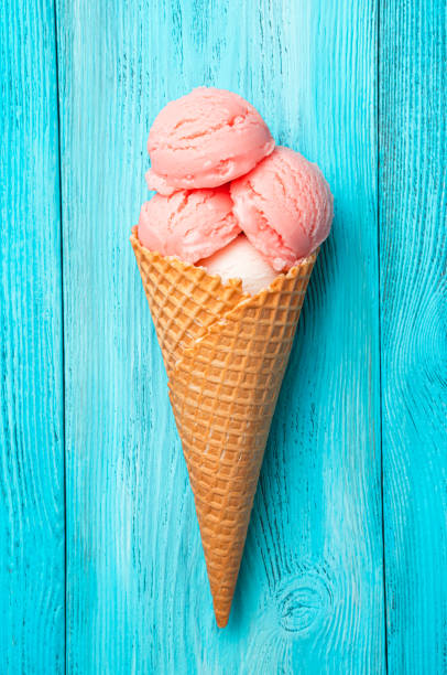 istock Raspberry ice cream in a waffle cone on a blue background. 1397758299