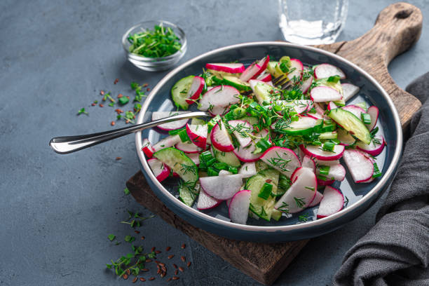istock Fresh vegetable salad with radishes and fresh herbs on a graphite background. 1397758302