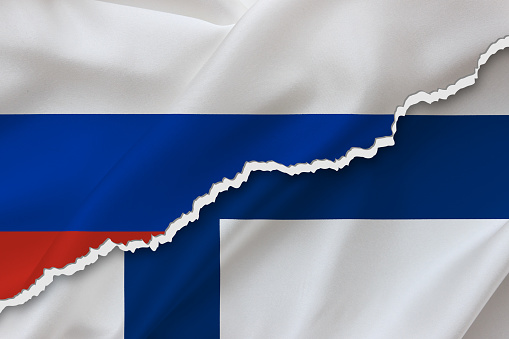 Finland and Russia waving silk flag ripped paper background.  Finland versus Russia concept.
