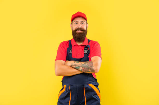 istock happy bearded man repairer in work clothes on yellow background 1397759927