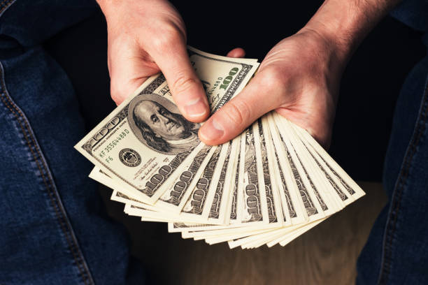 istock Male hands holding us hundred dollars banknotes 1397760796