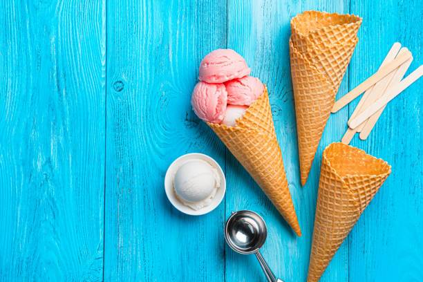 istock Berry and cream ice cream, waffle cups and a spoon on a blue background. 1397760934