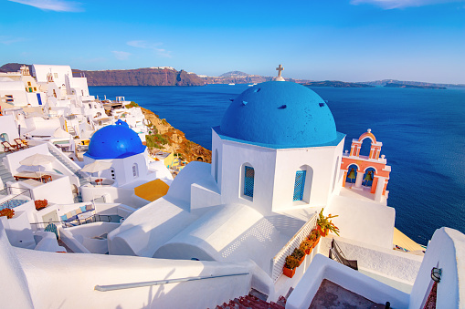 Oia town on Santorini island, Greece. Traditional and famous houses and churches with blue domes over the Caldera, Aegean sea