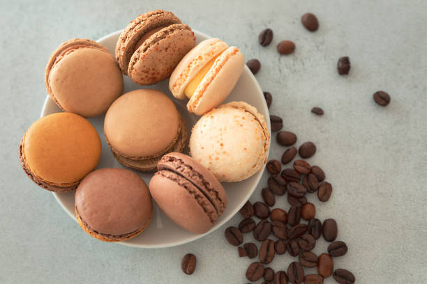 istock Plate with macarons cake and coffee beans on a gray background, top view 1397763862