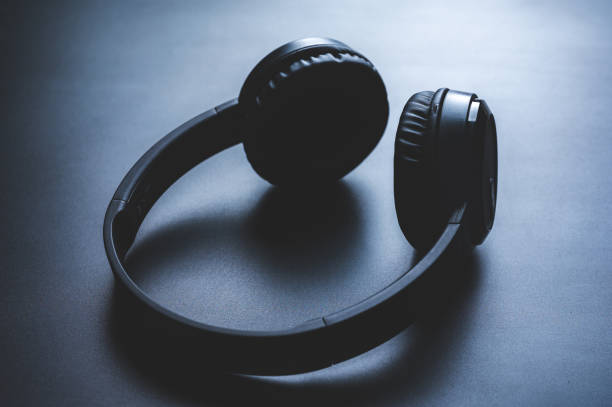 istock Solo wireless black bluetooth headphones lying alone on black background 1397763974