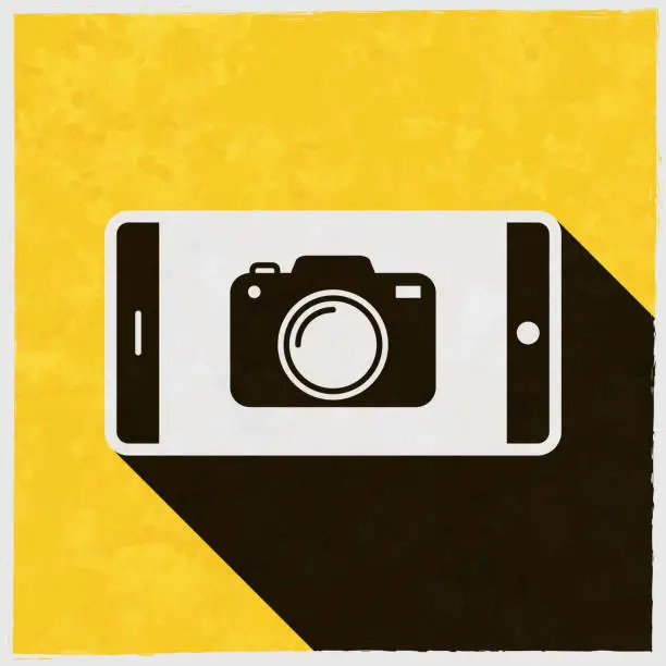 Vector illustration of Smartphone with camera. Icon with long shadow on textured yellow background