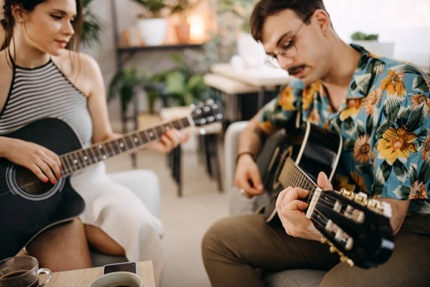 istock Young couple relaxing at home playing guitar 1397767306