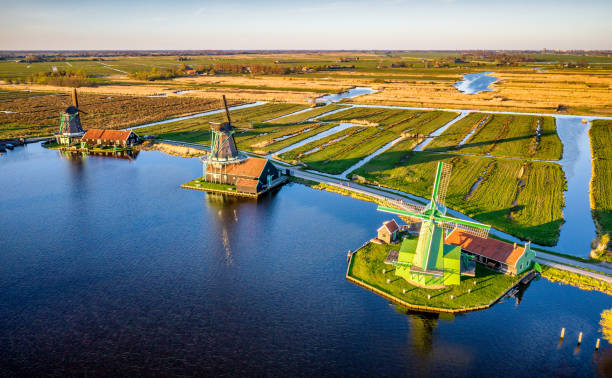 windmills at zaanse schans in holland at sunset. zaandam, netherlands - zaanse schans bridge house water imagens e fotografias de stock