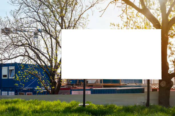 istock Blank white billboard for advertisement in front of the construction site. Apartment building under construction on a sunny day. 1397771399