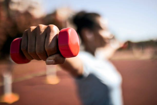 istock Woman Exercising with weights ,focus on dumbbell 1397776211