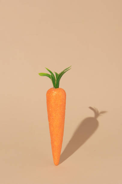 istock Carrot with her shadow on pastel beige background 1397776230