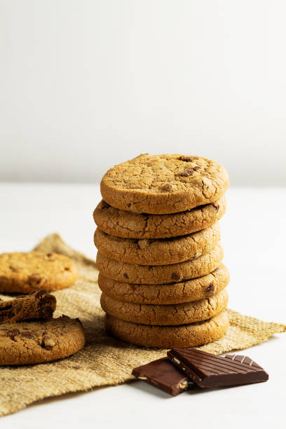 istock chocolate chip cookies.stack of biscuits with chocolate pieces on the sackcloth with copy space on white background. Chocolate cookies on white linen napkin on wooden table. vertical 1397776880