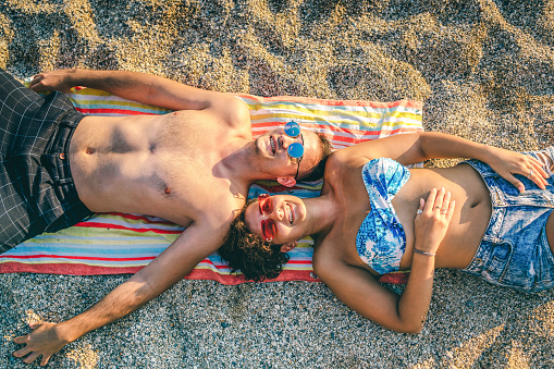 Young cheerful couple relaxing on the beach