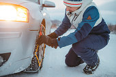 Close-up of a Man Installing Tire Chains on a Car