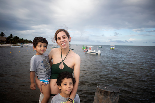 mother and two kids on pier, Puerto Morelos