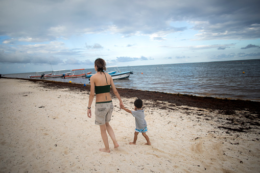 mother and son walking on the beach, Puerto Morelos