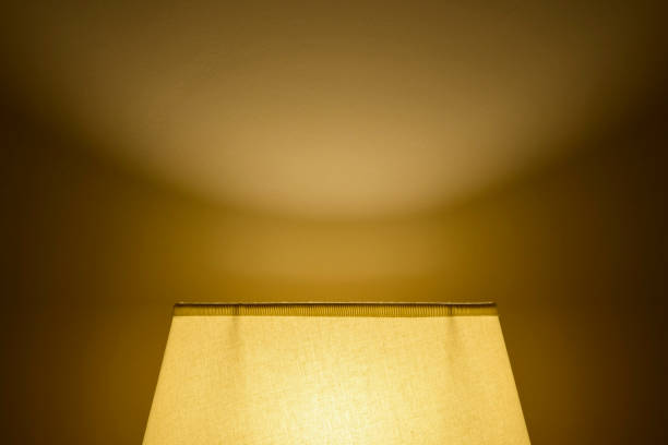 istock Soft light from a lamp shade on the wall in a dark room. Backlight from below. 1397779135