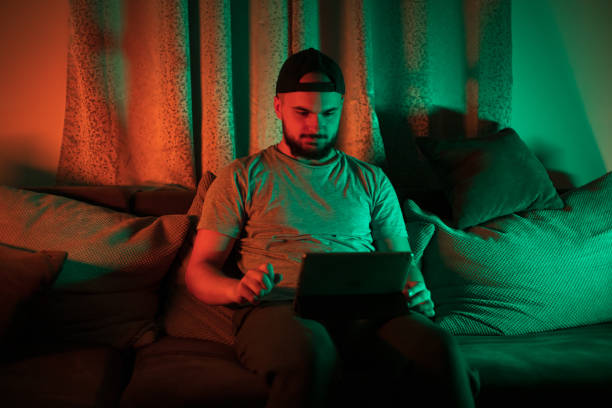 istock Young man sitting in a cosy couch using digital tablet 1397779286