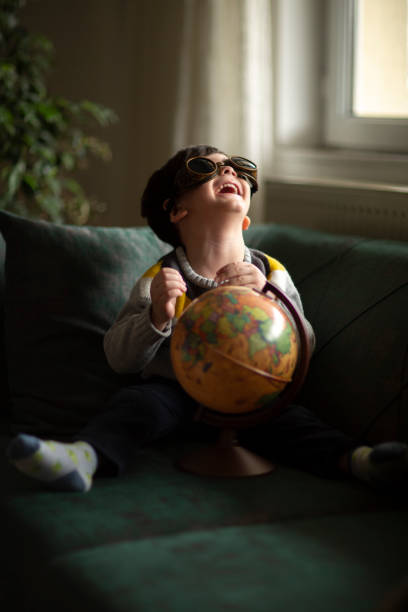 小さな男の子が地図を調べる - travel globe student journey ストックフォトと画像