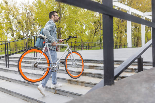 istock Young man carrying a bicycle on stairs 1397780474