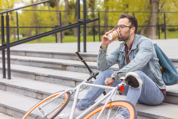istock Guy sitting on a stairs having a coffee 1397780478
