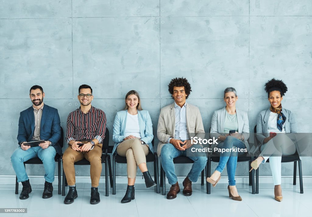 man business chair sitting waiting woman businessman candidate recruitment businesswoman office businessperson job young interview line Group of young business people sitting in chairs and waiting for an interview New Hire Stock Photo