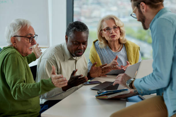 istock Multicultural group of senior students asking questions their tutor who showing them solution. 1397783854