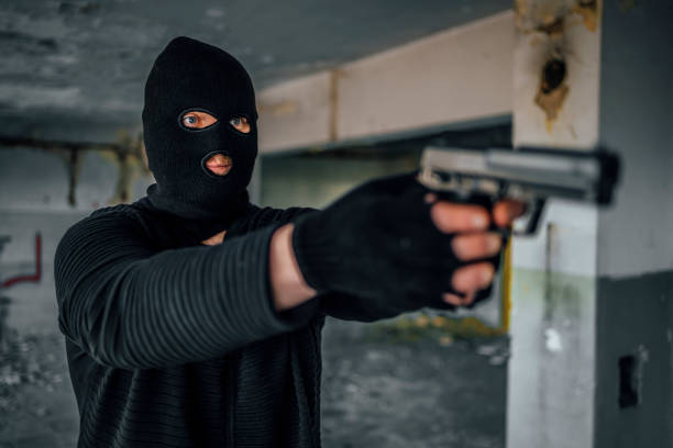 homem com uma máscara segurando arma - gun handgun violence kidnapping - fotografias e filmes do acervo