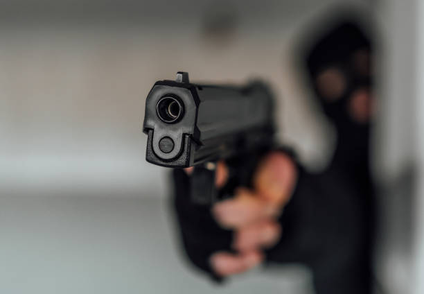 istock Man with a mask holding gun 1397785523