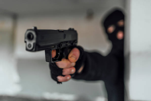 istock Man with a mask holding gun 1397785558