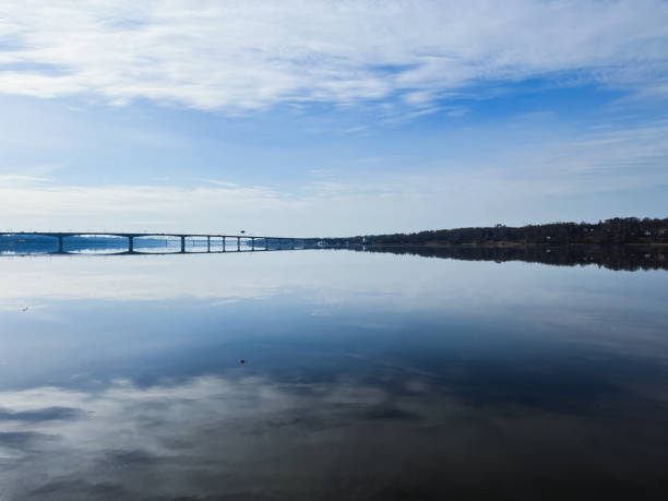 istock Peaceful sky reflection on the river surface, tender blue sky and bright water. Bridge on the horizon 1397787767