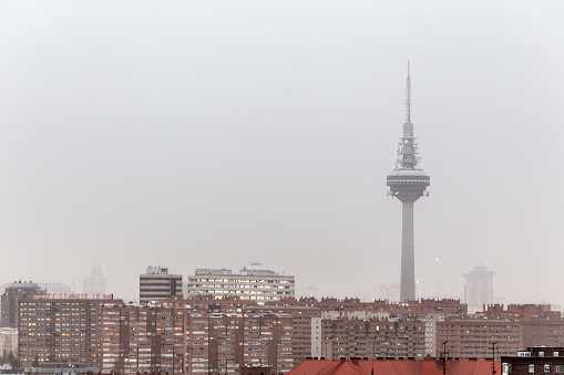 Madrid, Spain. March 15 2022. Spanish TV communications tower and adjoining buildings under pollution cloud and haze