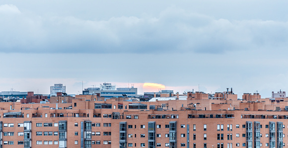 Madrid, Spain. March 26 2022. Sun hiding behind residential buildings