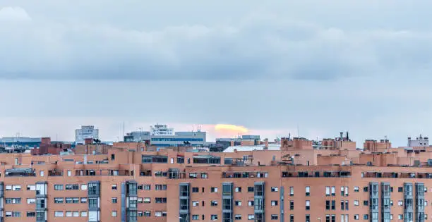 Photo of Sun hiding behind residential buildings