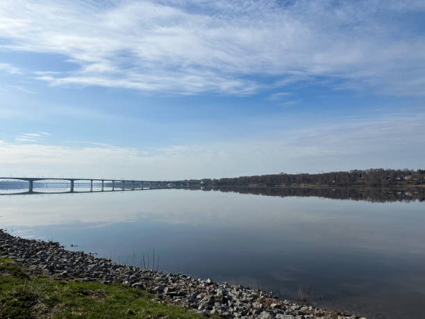 istock Peaceful sky reflection on the river surface, tender blue sky and bright water. Bridge on the horizon 1397788109