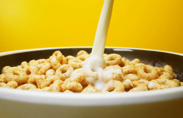istock Pouring milk in bowl with round honey cereals. 1397789267