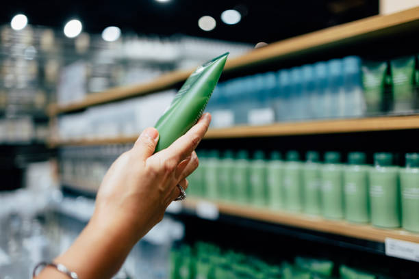 A Close Up View Of An Unrecognizable Females Hand Holding Some Beauty Product A cropped photo of an anonymous Caucasian woman holding a tube of a hand cream while shopping at a store. asian skincare products stock pictures, royalty-free photos & images